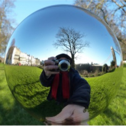Professor Sir Michael Berry, demonstrating one of the optical illusions he will discuss at his EKA talk Picture of Professor Sir Michael Berry reflected in a glass ball